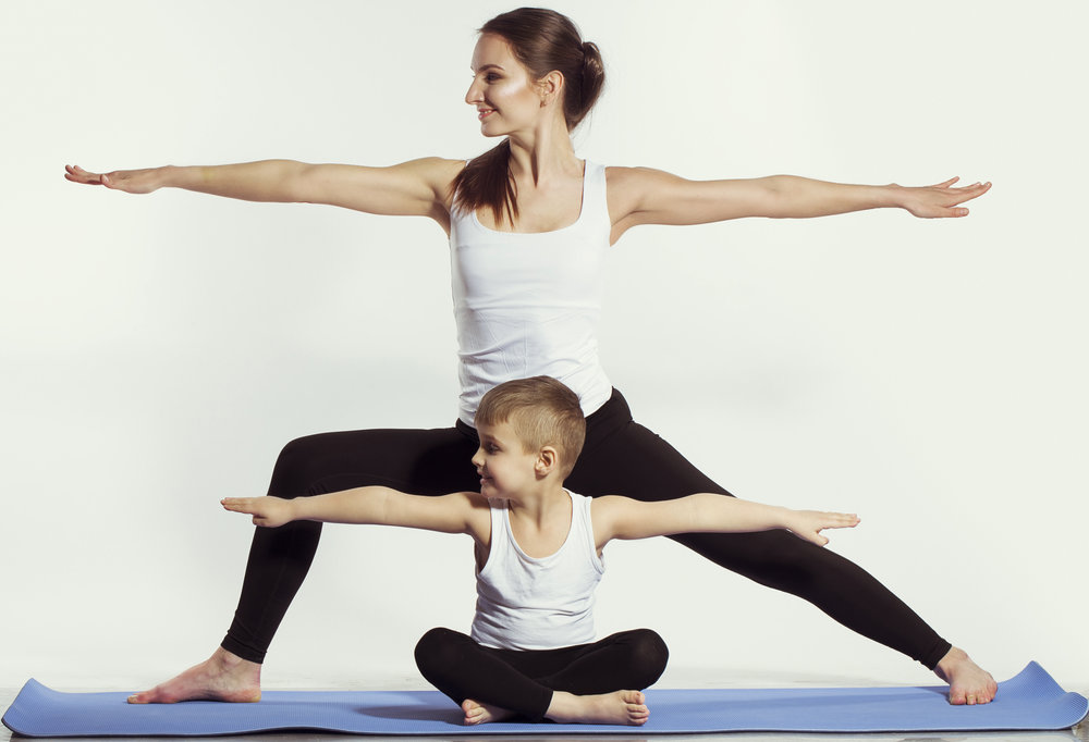 woman doing yoga pose with her son