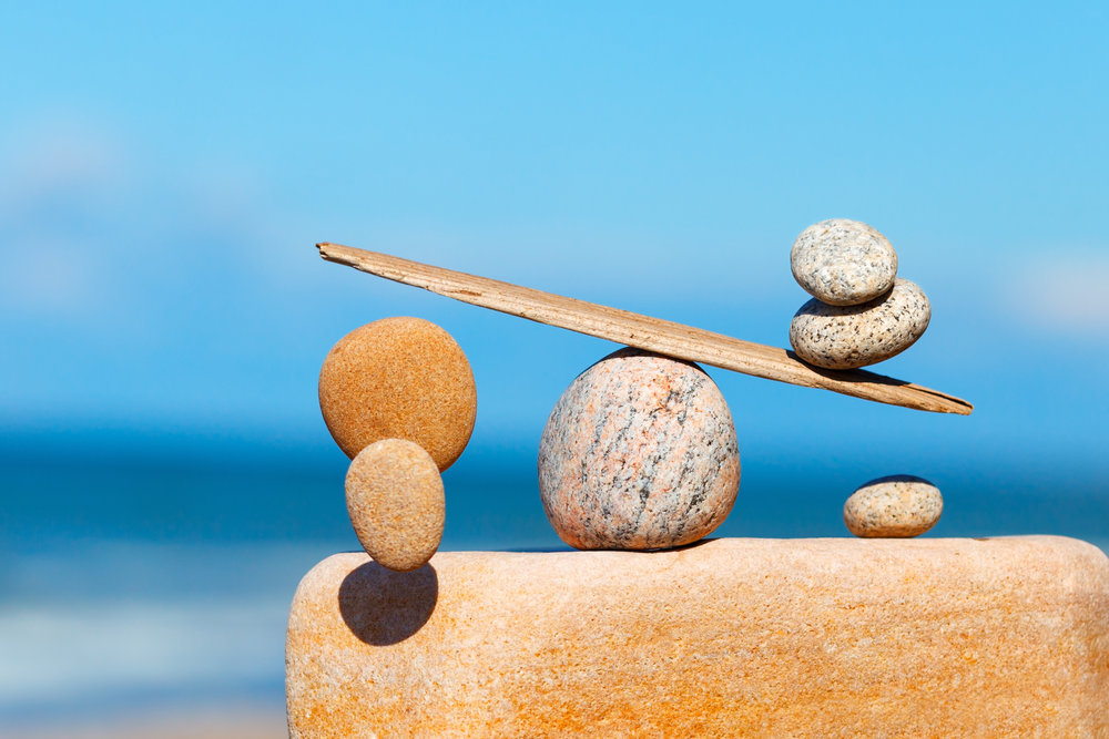 stones balancing on a piece of wood