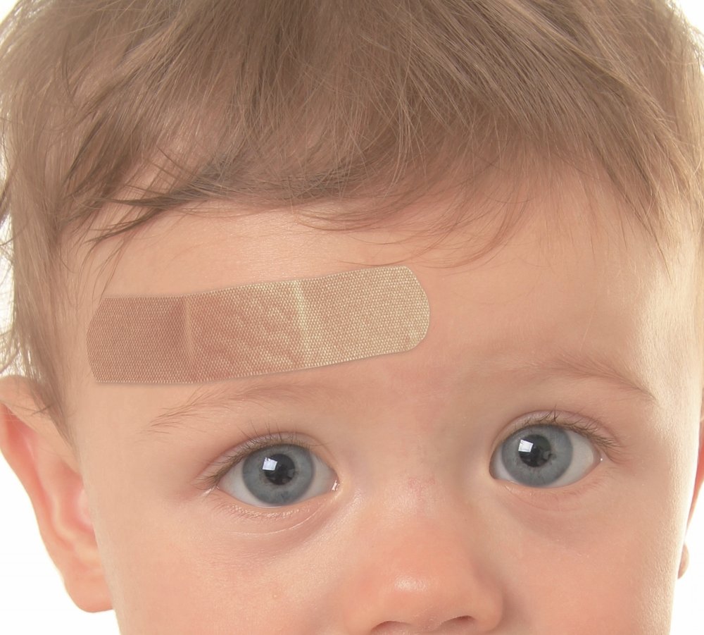 a child with a band-aid on forehead