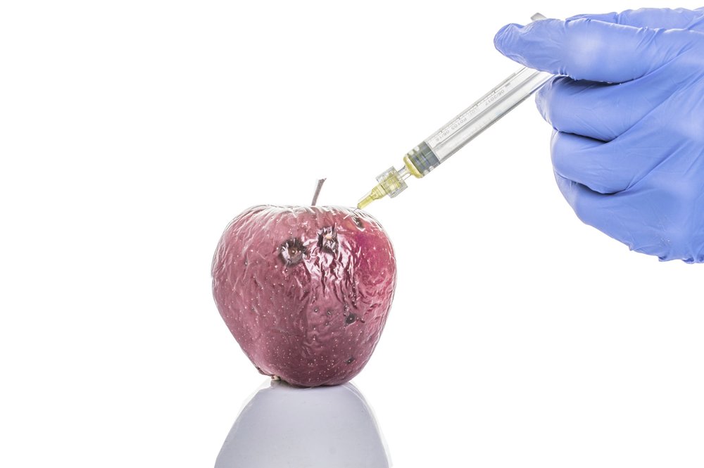 an apple being injected with a needle