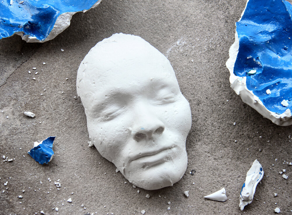 a plaster face shattered on ground