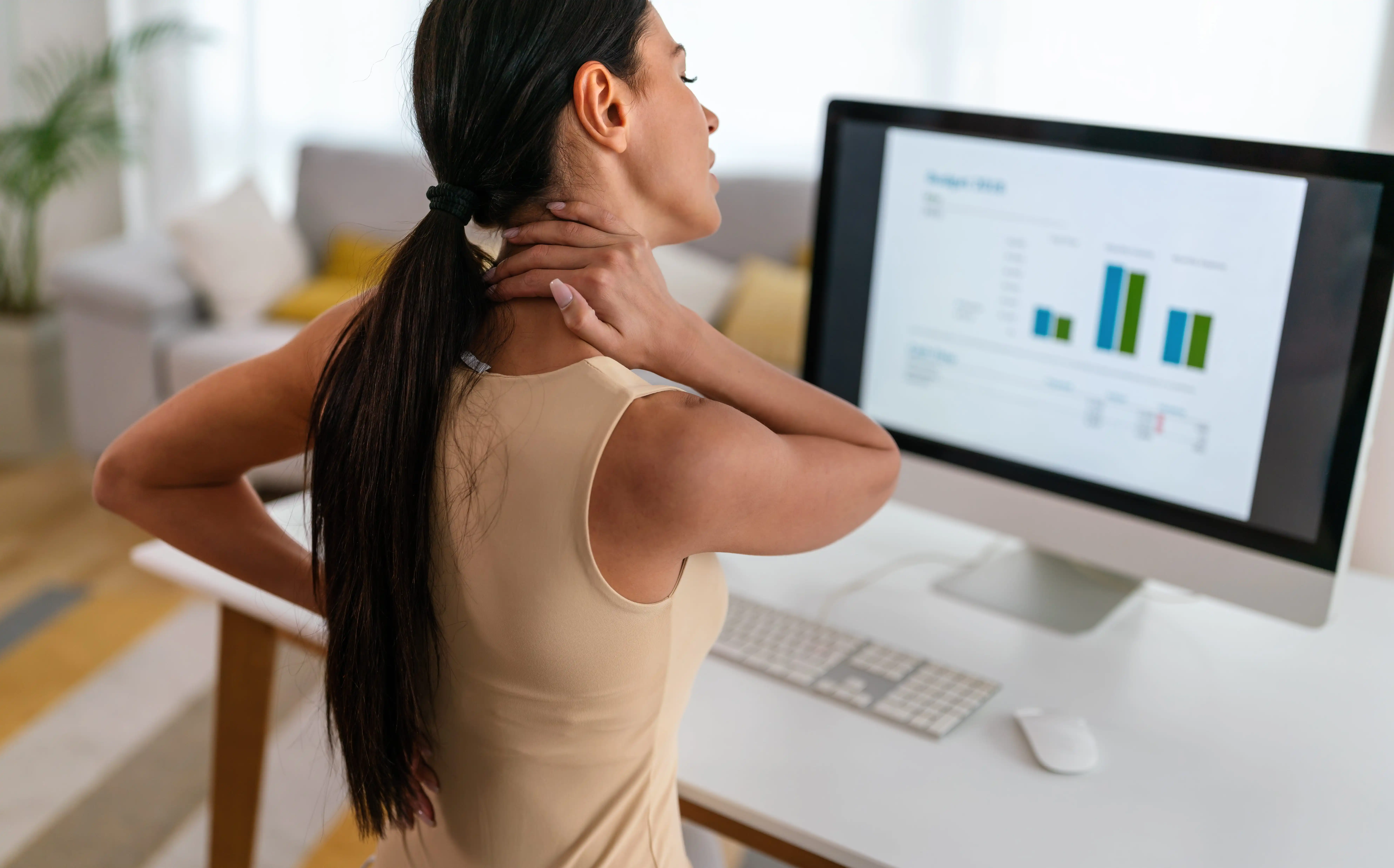 Woman experiencing neck and back pain, a common symptom of macromastia and large breasts